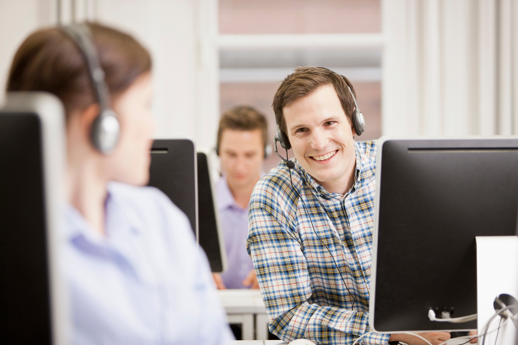 man smiling behind computer